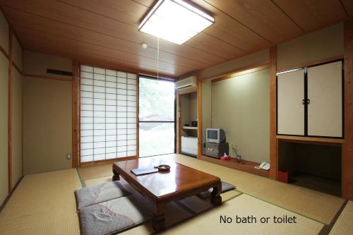 ein Wohnzimmer mit einem Tisch und einem Sofa in der Unterkunft Tokonamiso in Nagiso