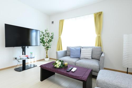 salon z kanapą i telewizorem w obiekcie SAKURA93 w mieście Sapporo