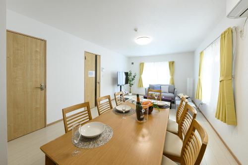 - une salle à manger avec une table et des chaises en bois dans l'établissement SAKURA93, à Sapporo