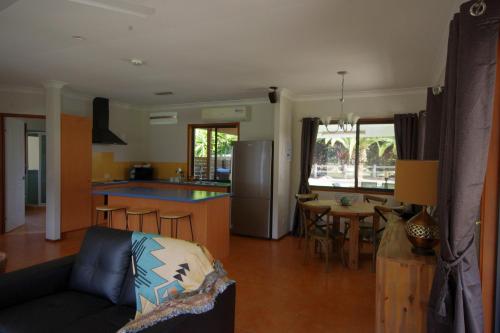 a living room and kitchen with a couch and a table at Canungra Valley Cottage in Canungra