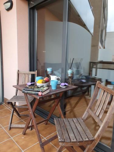 una mesa de madera con 2 sillas y una sombrilla en Deltebre Apartamentos, en Deltebre