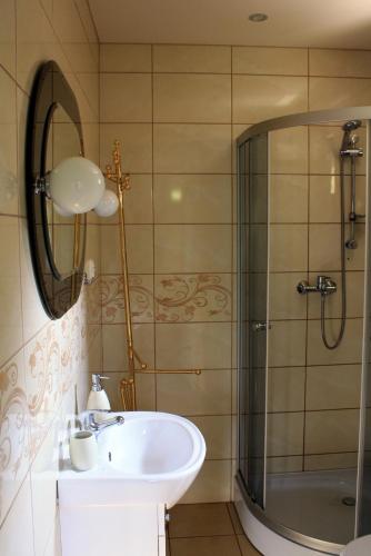 a bathroom with a sink and a shower at Domek Gloria nad Jeziorem Żywieckim in Żywiec