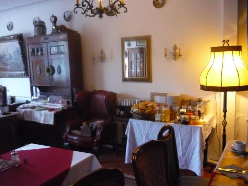 a dining room with two tables and a lamp at Hotel an der Fähre in Sankt Goar