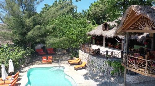 a resort with a swimming pool and a building at Tensing Pen in Negril