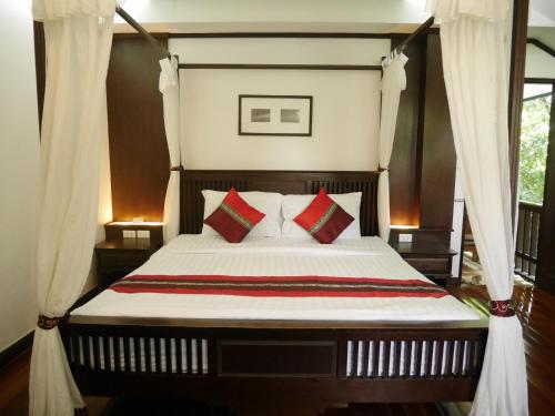 a bedroom with a bed with red and green pillows at PingPhuPlace Smart Check-in in Chiang Mai