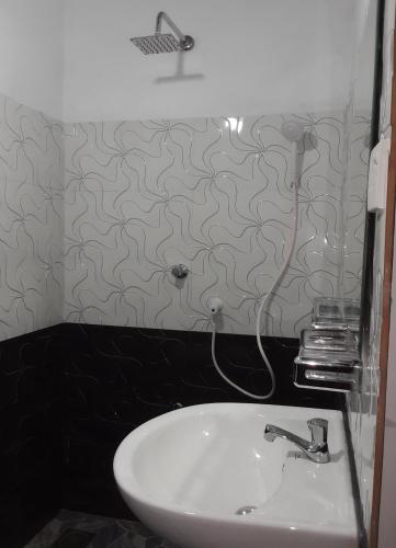 a white sink in a bathroom with a wall at Villa Sidu in Induruwa