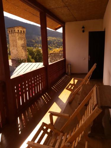 a room with a balcony with a view of a tower at Svan House In Mestia in Mestia