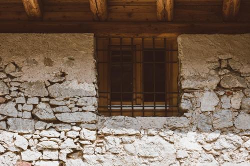 a window of an old stone building with a bars at Limarò B&B in Sarche di Calavino