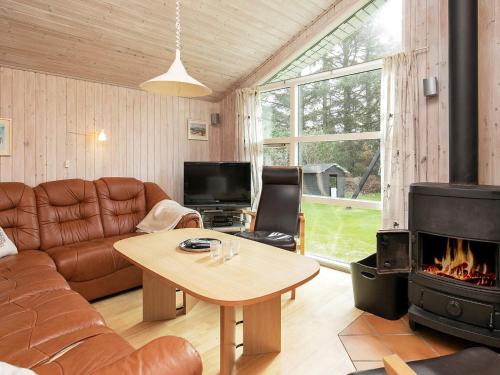 sala de estar con sofá y chimenea en 8 person holiday home in Hj rring, en Hjørring