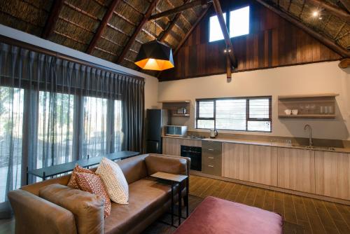 a living room with a couch and a kitchen at Buckler's Africa Lodge Kruger Park in Komatipoort