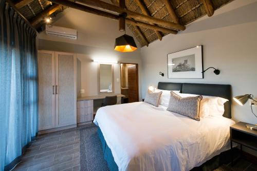 a bedroom with a large white bed in a room at Buckler's Africa Lodge Kruger Park in Komatipoort