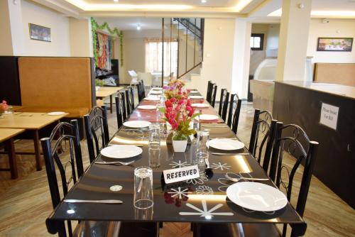 uma mesa longa com pratos e flores em Roopkatha Hotel Kalimpong em Kalimpong