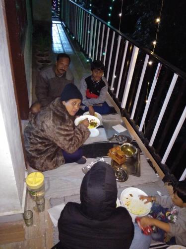 een groep mensen die rond een tafel zitten en eten bij Peaceful Dalhousie in Dalhousie