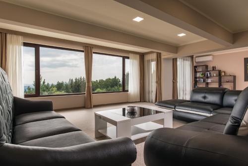 a living room with two couches and a table at Hotel Villa Magus in Kladnitsa