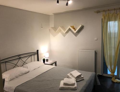 a bedroom with a bed with towels on it at SEASIDE SUNSET WALKS in Athens