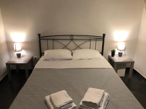- une chambre avec un grand lit et 2 tables de chevet dans l'établissement SEASIDE SUNSET WALKS, à Athènes