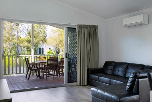 a living room with a couch and a table and chairs at Discovery Parks - Byron Bay in Byron Bay
