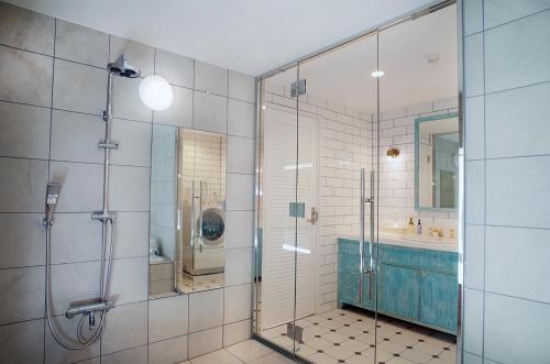 a bathroom with a glass shower and a sink at La Krasse Angelroad in Tonosho