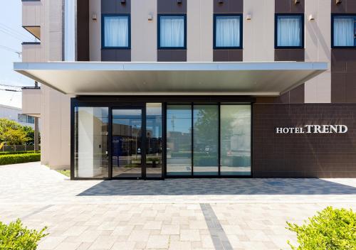 a hotel entrance with glass doors in front of a building at Hotel Trend Mikawaanjo in Anjo