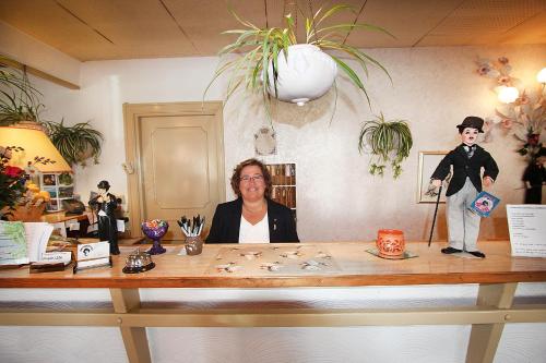 
a woman standing in front of a counter filled with bottles at Hotel Chaplin in Landskrona
