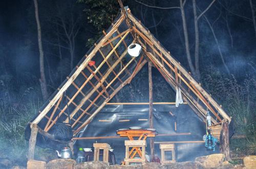 a house with a roof with a table and a stove at Eco Lodge Haputale-Camping Sri lanka in Haputale