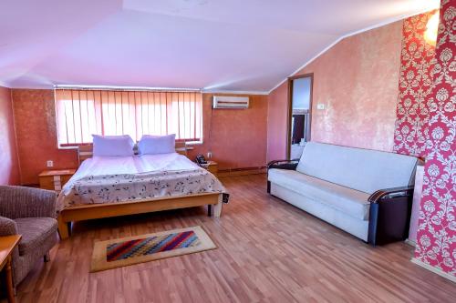 シゲトゥ・マルマツィエイにあるMotel Perla Sigheteanaの広いベッドルーム(ベッド1台、ソファ付)