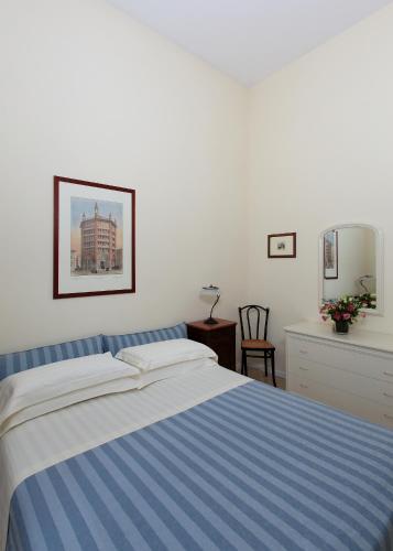 a bedroom with a blue and white bed and a mirror at Residence Liberty in Parma