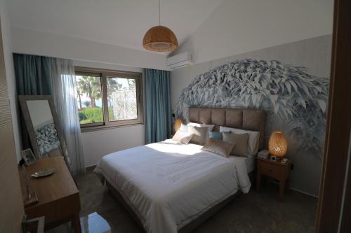a bedroom with a bed with a large headboard at Yulya Villa By Taimoura in Paphos