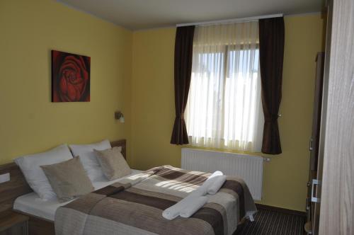 a bedroom with a bed and a window at Hotel Zarja in Pohorje