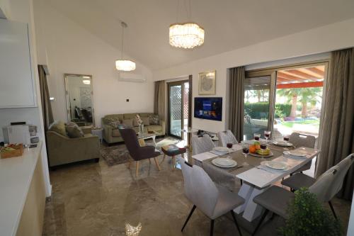 a dining room and living room with a table and chairs at Yulya Villa By Taimoura in Paphos