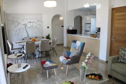 a living room with a table and chairs and a kitchen at Yulya Villa By Taimoura in Paphos