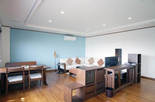 a living room with a couch and a table at La Krasse Angelroad in Tonosho