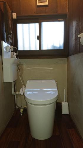 a small bathroom with a toilet and a window at みのり家 - Samurai-era house - 昔の暮らし体験 in Takayama