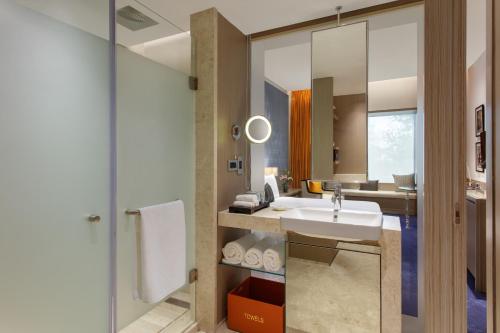 ein Bad mit einem Waschbecken und einem Spiegel in der Unterkunft Welcomhotel by ITC Hotels, Raja Sansi, Amritsar in Amritsar