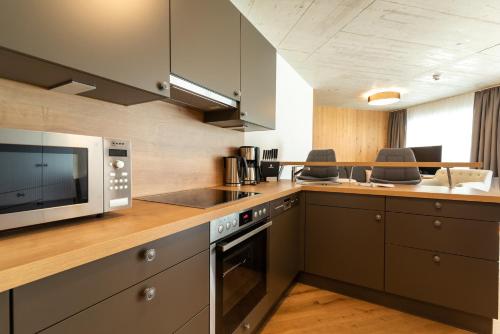 a kitchen with a microwave and a stove top oven at A Casa Elegance in Längenfeld