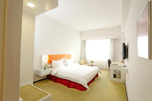um quarto de hotel com uma cama e uma janela em Borneo Royale Hotel em Tawau