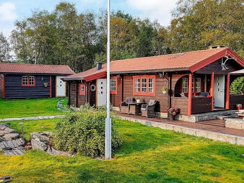 a log cabin with a porch in a yard at 6 person holiday home in Frei in Frei
