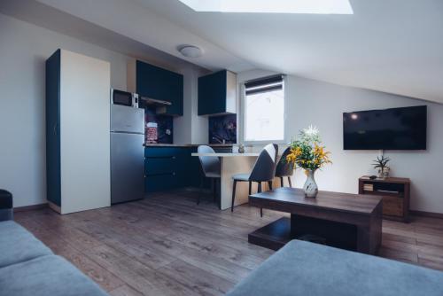a living room with blue cabinets and a table at Seasons apartmani in Osijek