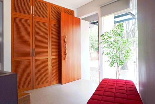 une chambre avec un banc rouge à côté d'une porte dans l'établissement HM SOCIAL Karawaci, à Tangerang