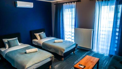 a blue room with two beds and a table at Kaktus Chill & Sleeping - 50 m od Rynku in Racibórz