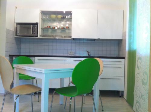 a kitchen with a blue table and green chairs at A Little Home in Rust