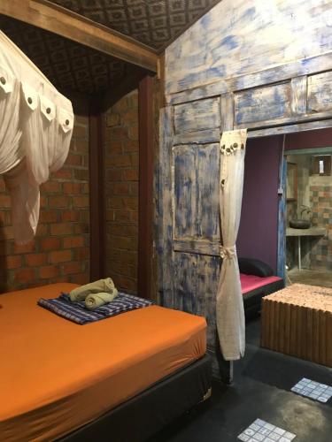 a bedroom with two beds and a wooden wall at Arjuna Garden Homestay in Yogyakarta