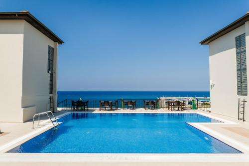 a swimming pool with a view of the ocean at Olivia Palm Hotel in Kyrenia
