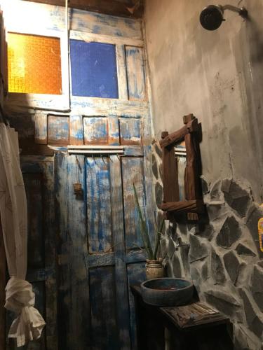 a bathroom with a wooden door and a window at Arjuna Garden Homestay in Yogyakarta
