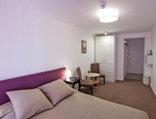 a bedroom with a purple bed and a living room at Apple Inn in Warsaw