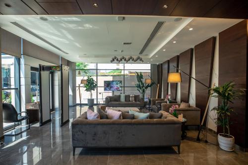 a living room with a large couch in a lobby at The Compass Hotel in Amman