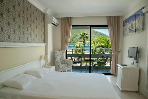a bedroom with a bed and a view of a balcony at Hotel Chateau de Ville in Marmaris