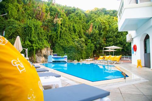 a swimming pool with tables and chairs next to a building at Hotel Chateau de Ville in Marmaris
