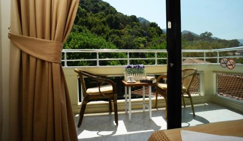 a balcony with a table and chairs and a window at Hotel Chateau de Ville in Marmaris