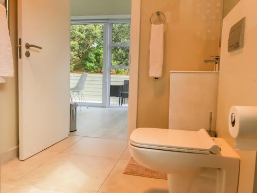 a bathroom with a toilet and a view of a patio at Mount Bay in Hout Bay